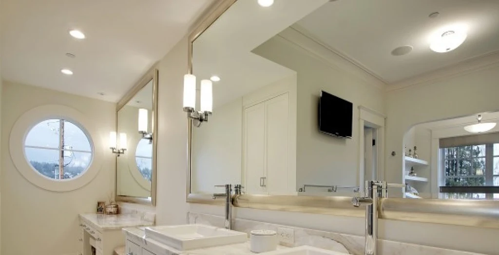 Large wall mirrors above a bright bathroom vanity