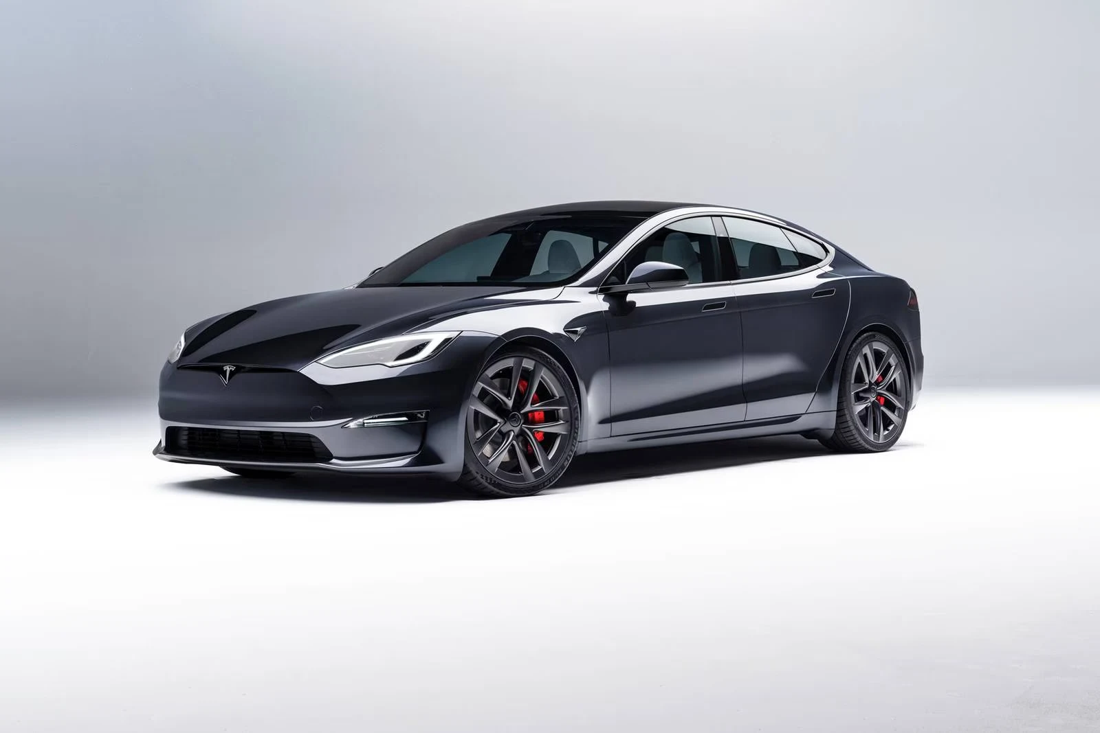 Dark electric sedan photographed against a light studio background