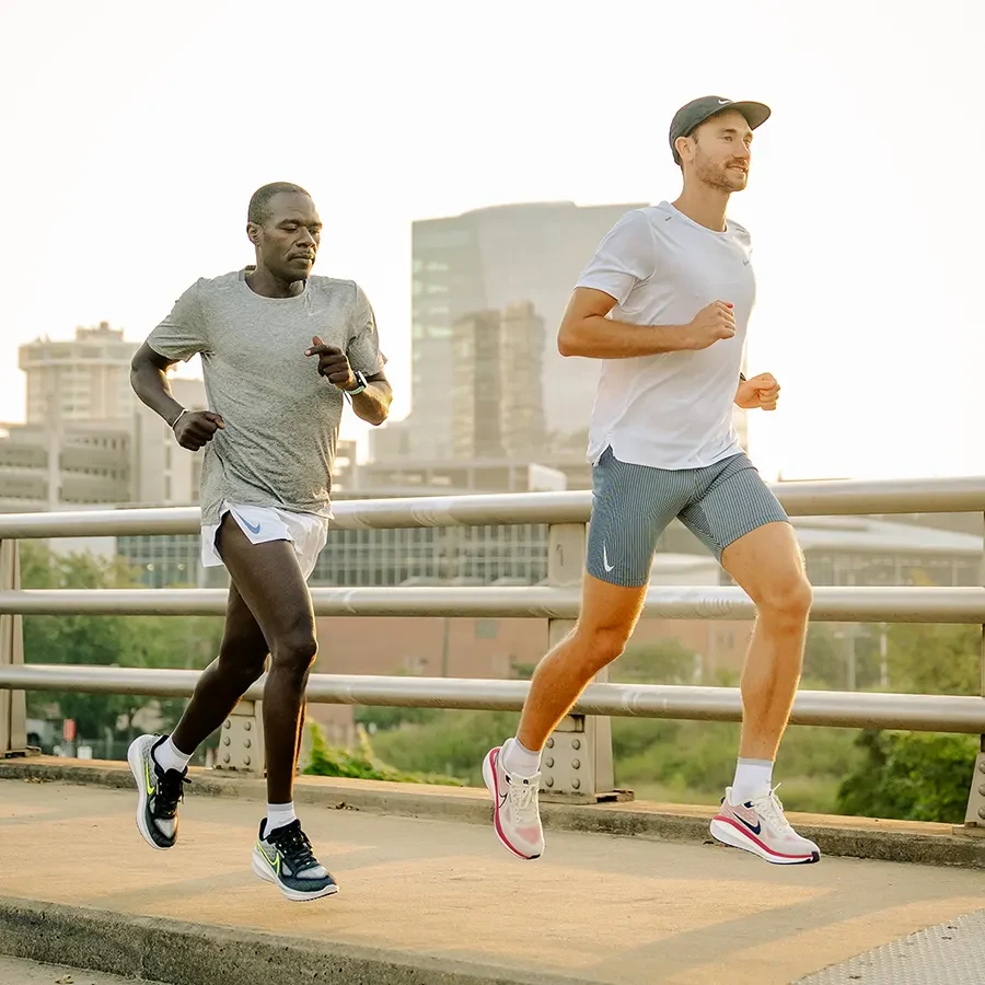 Two runners jogging together on an urban path