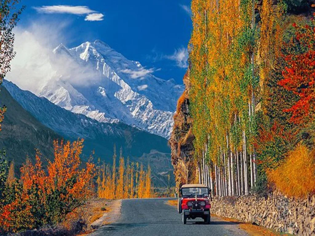 Road passing through an autumn valley beneath high mountains