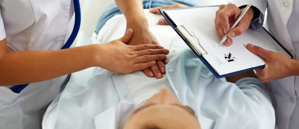 Healthcare professionals discussing notes with a patient during a medical appointment