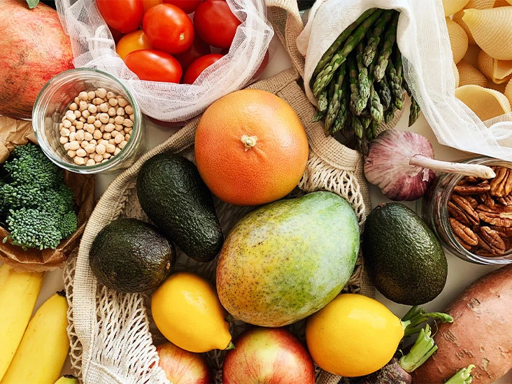 Assorted fresh fruit and vegetables arranged in reusable shopping bags