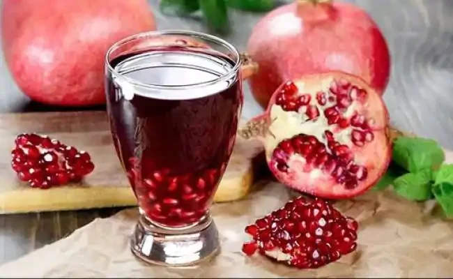 Pomegranate juice with whole and cut pomegranates