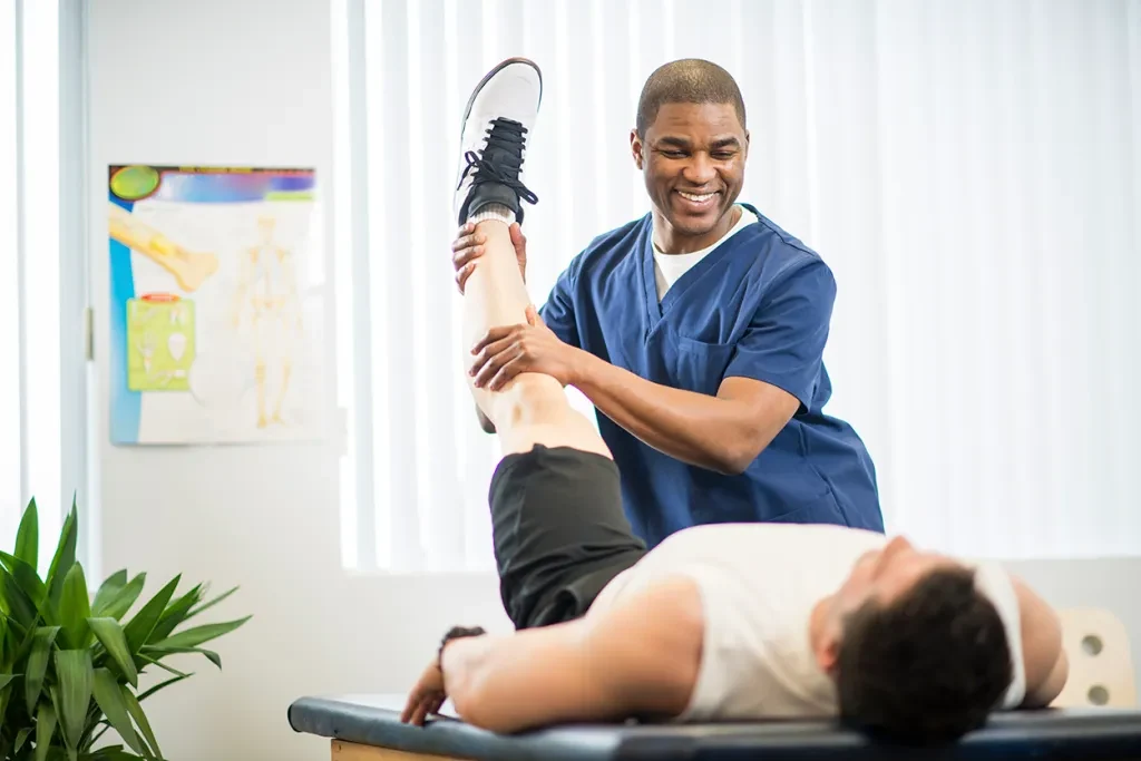 Physiotherapist guiding a patient through a supervised leg movement