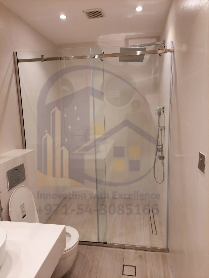 Frameless sliding shower glass partition installed in a Dubai bathroom.