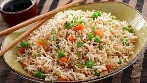 Plate of sizzling Chinese fried rice with vegetables.