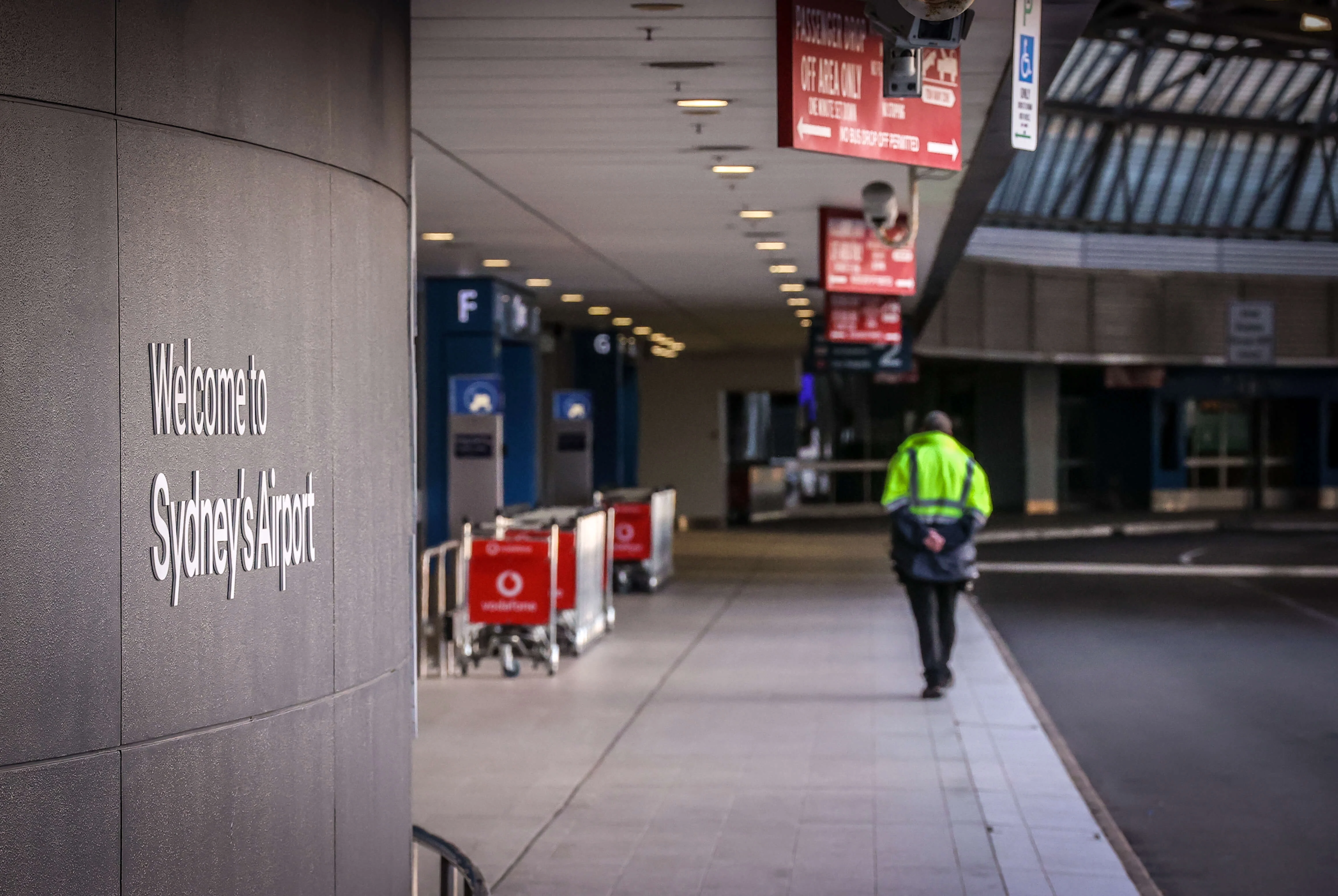 Entrance to Sydney Airport with a staff member walking nearby